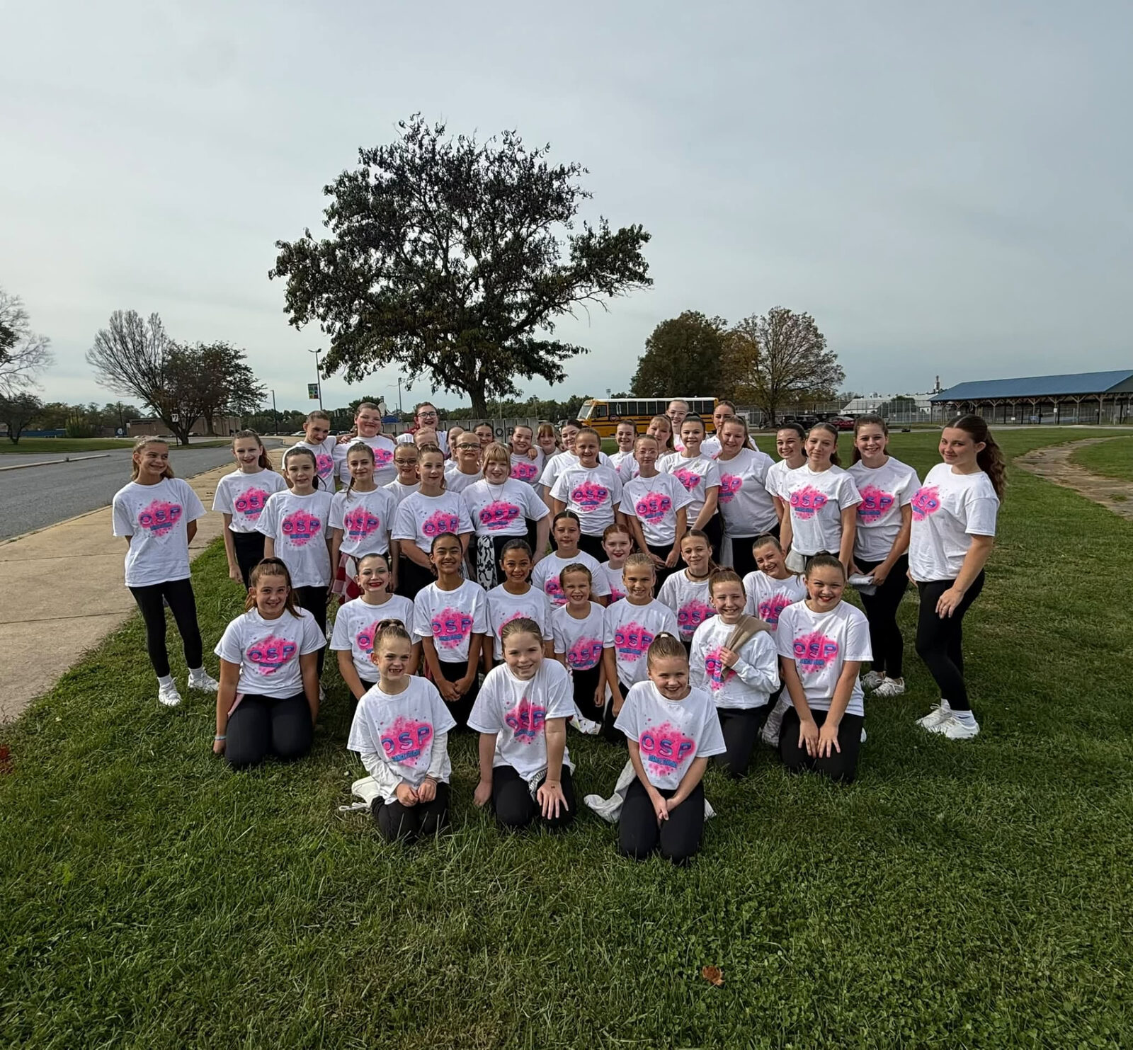 A large group of On Stage dancers in matching shirts outdoors