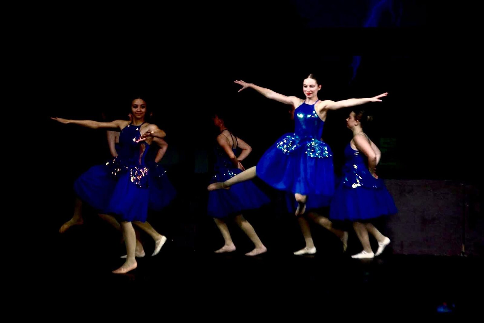 Dancers in blue costumes performing on stage